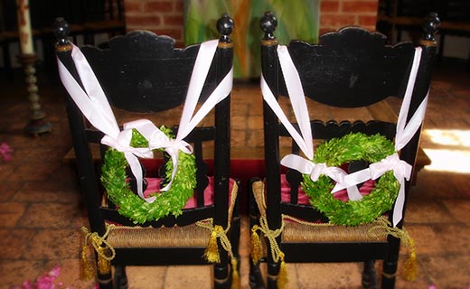 Braut-Stühle mit gebundenen Kränzen für Brautpaar